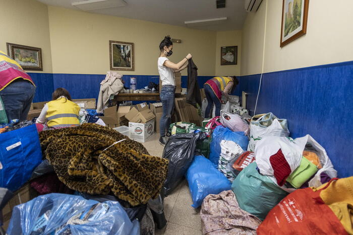 Volontari preparano pacchi con indumenti per i rifugiati.