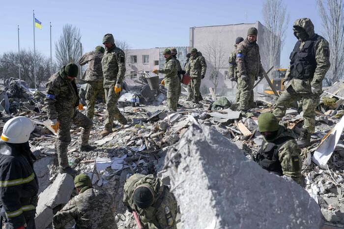 Soldati ucraini ricercano sopravvissuti tra le macerie di edifici distrutti dai bombardamenti russi
