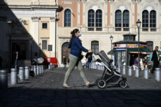 In una foto d'archivio una mamma con passeggino in piazza San Silvestro, Roma.