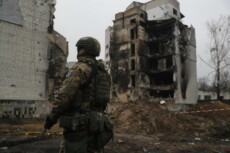 Soldato ucraino di fronte alle macerie di un edificio a Borodyanka
