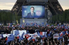 Fans del presidente Emmanuel Macron festeggiano la vittoria nelle elezioni presidenziali sotto la Torre Eiffel.