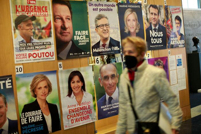 Una donna passa davanti ai manifesti della propaganda elettorale dei candidati alla presidenza in Francia.