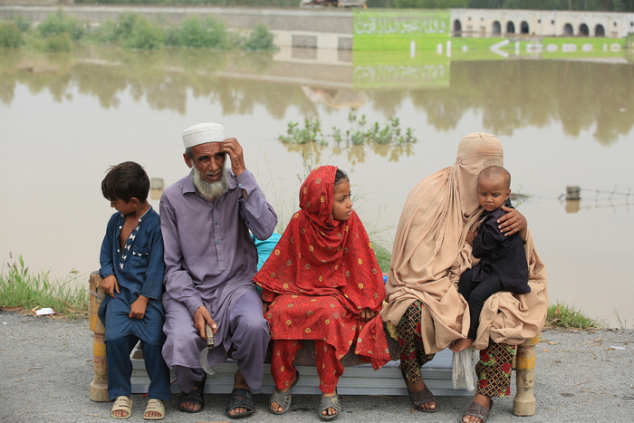 Alcune persone aspettano il riflusso delle acque per tornare nelle proprie case nel Distretto di Charsadda, Pakistan, 27 Agosto 2022. EPA/ARSHAD ARBAB