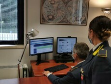Ufficiali della Guardia di Finanza effettuano dei controlli al computer.