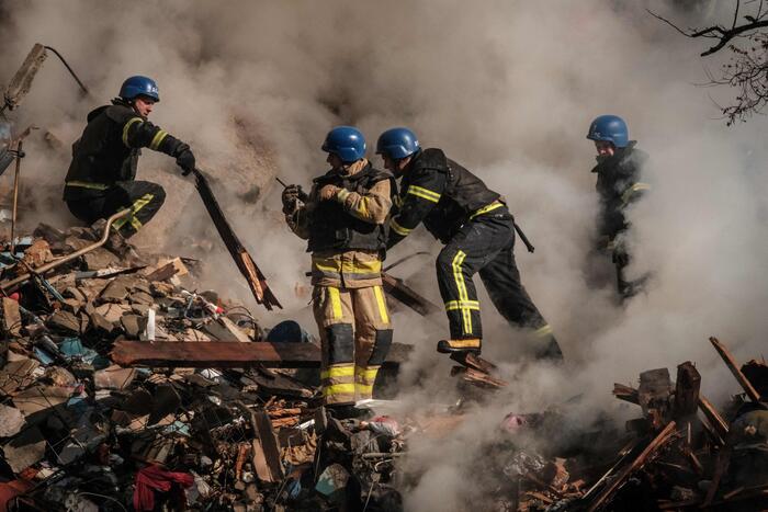 Pompieri ucraini al lavoro tra le macerie dopo l'esplosione del drone.