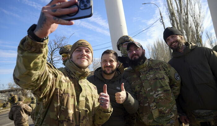 Il presidente ucraino Volodymyr Zelensky posa per un selfie con i soldati di stanza a Kherson.