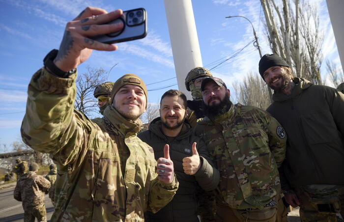 Il presidente ucraino Volodymyr Zelensky posa per un selfie con i soldati di stanza a Kherson.